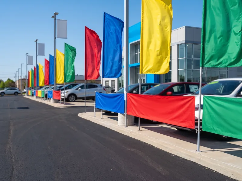 Banners and lot flags lining the front row of an auto dealership
