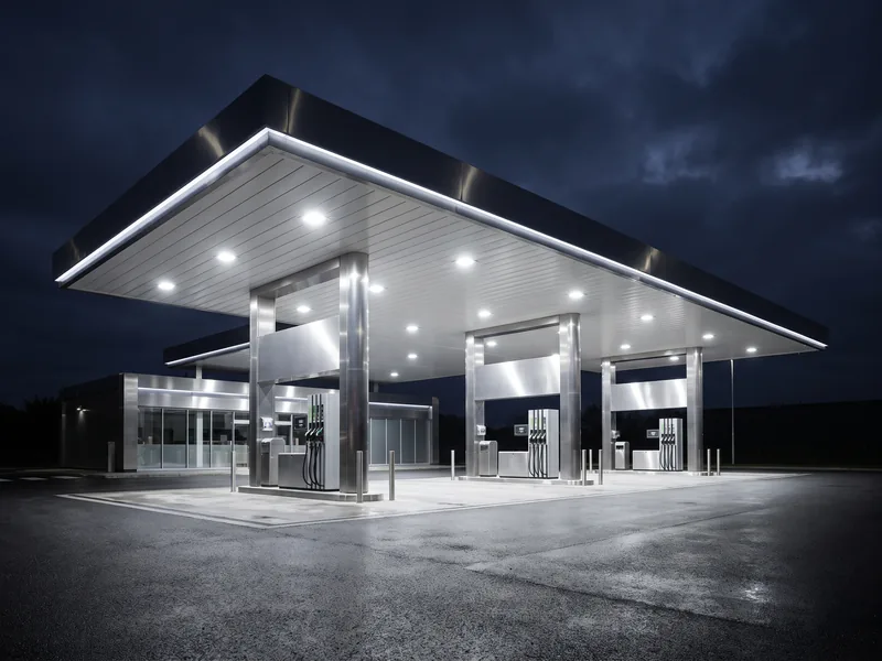A brightly LED-lit gas station fuel canopy at night after a lighting retrofit