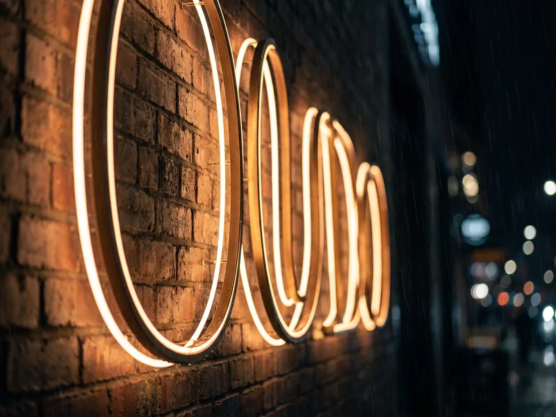 Halo-lit script letters glowing against a brick storefront at night after installation