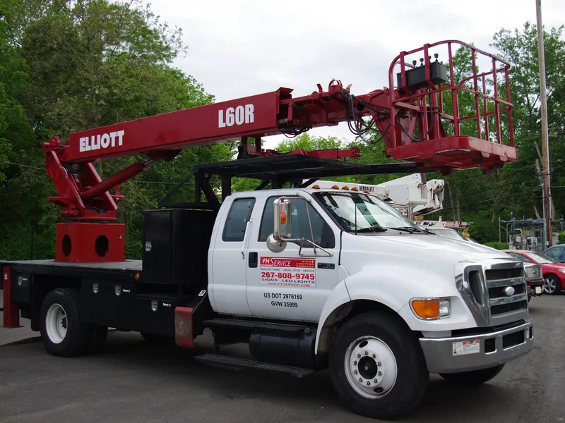 VH crane truck with the boom extended, set up for a high sign installation