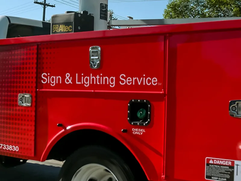Red VH service truck parked at a job site during a sign repair call