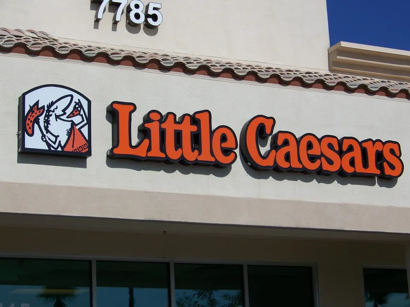 Front-lit red channel letters spelling Little Caesars mounted on a stucco storefront