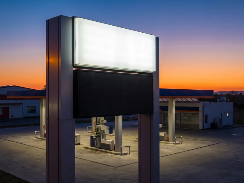 A gas station pylon with a brand cabinet above an LED fuel price display