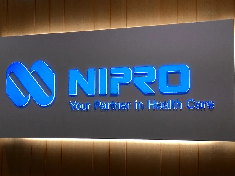 Illuminated Nipro flat panel sign with dimensional lettering mounted on an interior wall